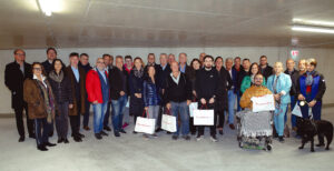 Gruppenbild mit künftigen Bewohner:innen und Ehrengäste in der Tiefgarage des Wohnbaus Hofstattgasse Weiz