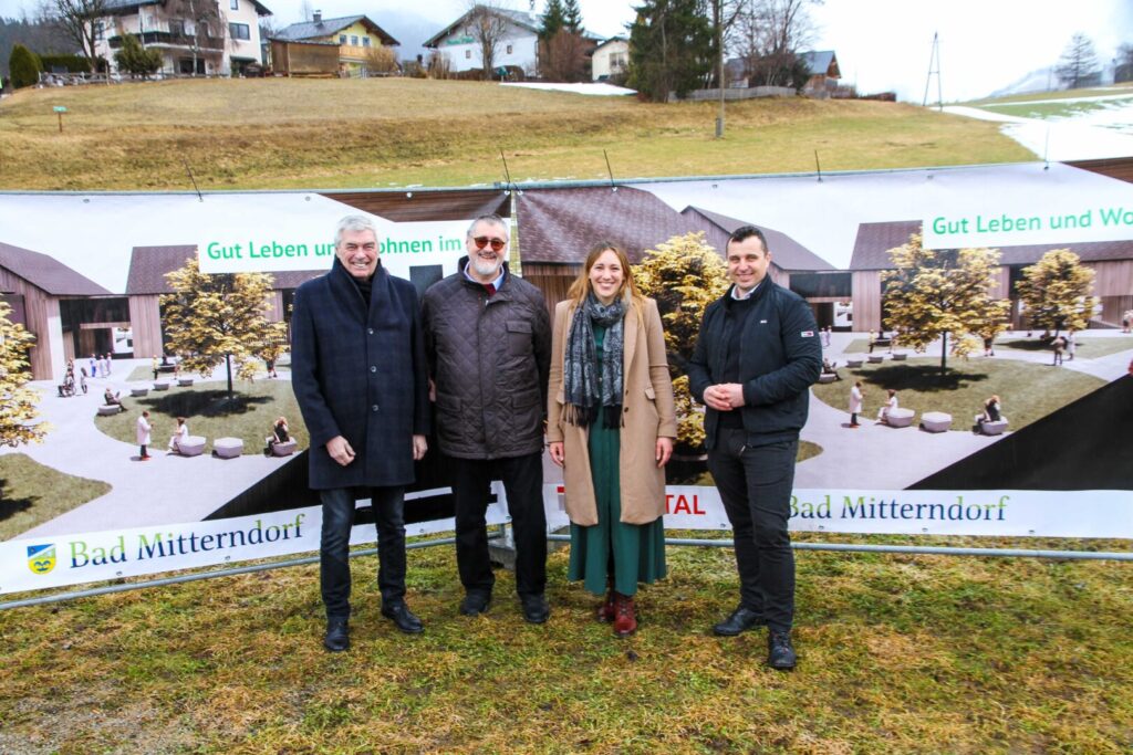 Gruppenfoto beim neuen Wohnbauprojekt in Bad Mitterndorf mit Bürgermeisterin Veronika Grill, Sacherer und Architekt Bernhard Schlömicher vor der zukünftigen Wohnanlage.